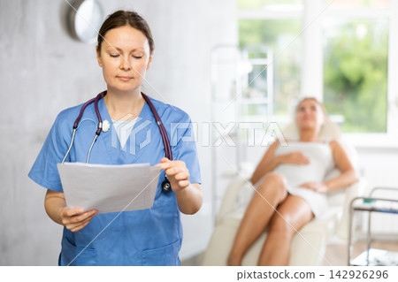 Medical specialist gets acquainted reads documents information about client of clinic Medical specialist gets acquainted reads documents information about client of clinic 142926296