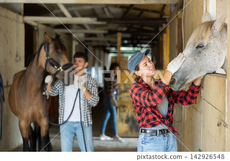 Portrait of woman horse farm worker standing at stable Portrait of woman horse farm worker standing at stable 142926548