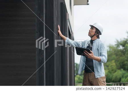 現場主管正在檢查外牆 現場主管正在檢查外牆 142927524