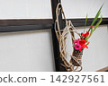 A basket made of vines and a flower arrangement. 142927561