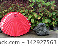 A Japanese umbrella and garden stones, a scene in the shade of the trees. 142927563