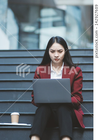 Asian woman in sitting at stairway outdoor have a stressed, after being laid off unemployed. Desperate be out of work. Asian woman in sitting at stairway outdoor have a stressed, after being laid off unemployed. Desperate be out of work. 142927689