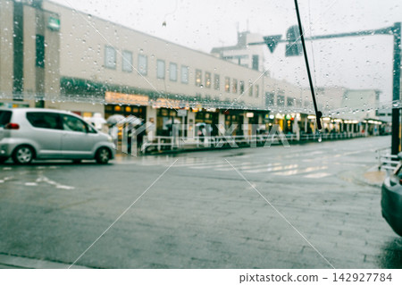 On a rainy day, the station square rotary seen through a plastic umbrella. On a rainy day, the station square rotary seen through a plastic umbrella. 142927784