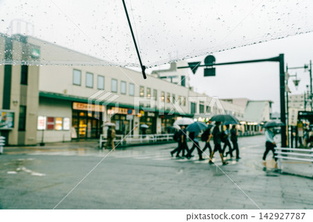On a rainy day, the station square rotary seen through a plastic umbrella. On a rainy day, the station square rotary seen through a plastic umbrella. 142927787
