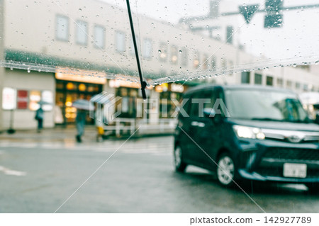 On a rainy day, the station square rotary seen through a plastic umbrella. On a rainy day, the station square rotary seen through a plastic umbrella. 142927789