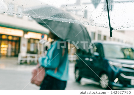 On a rainy day, the station square rotary seen through a plastic umbrella. On a rainy day, the station square rotary seen through a plastic umbrella. 142927790