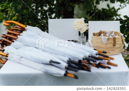 Wedding table with white umbrellas for guests outdoors. Wedding table with white umbrellas for guests outdoors. 142928301