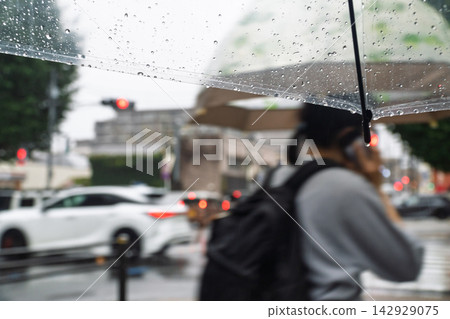 雨天，人們撐著傘走在人行道上。 142929075