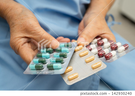 Asian elderly woman holding pill drug in hand, strong healthy medical. Asian elderly woman holding pill drug in hand, strong healthy medical. 142930240