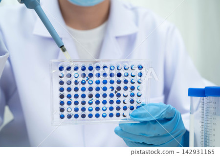 Scientist with cell culture in sample micro plate for research in science laboratory. 142931165