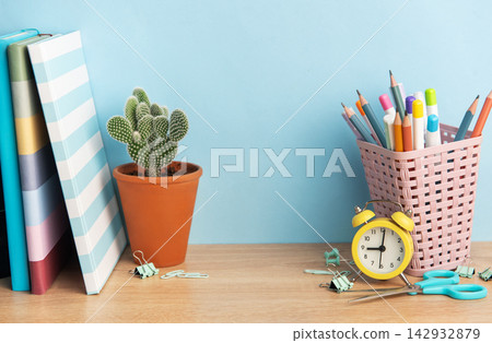 School desk with books, cactus, and stationery supplies School desk with books, cactus, and stationery supplies 142932879