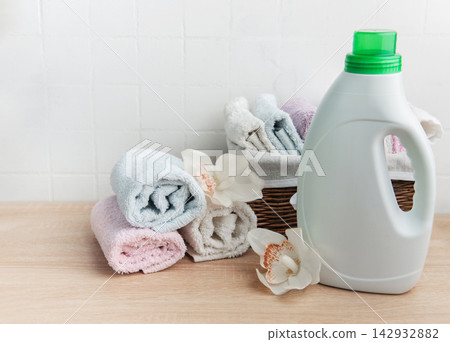Laundry detergent bottle with fresh clean towels and orchids 142932882