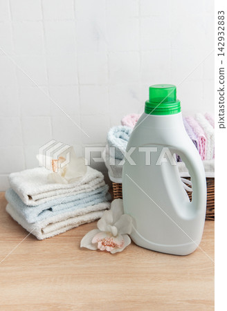 Laundry detergent bottle with fresh clean towels and orchids Laundry detergent bottle with fresh clean towels and orchids 142932883