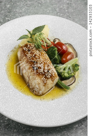asian style fusion cod fillet with vegetables and sweet sesame ginger sauce on restaurant table asian style fusion cod fillet with vegetables and sweet sesame ginger sauce on restaurant table 142933103