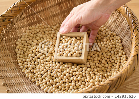 用量杯將黃豆從濾鍋中舀出。 用量杯將黃豆從濾鍋中舀出。 142933620