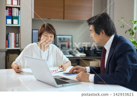 一對六十多歲的商人夫婦在辦公室開會。 一對六十多歲的商人夫婦在辦公室開會。 142933621