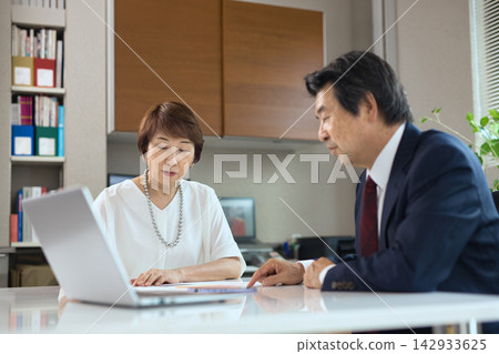 一對六十多歲的商人夫婦在辦公室開會。 一對六十多歲的商人夫婦在辦公室開會。 142933625