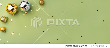 Christmas gold ornaments on a green background. Christmas gold ornaments on a green background. 142934007