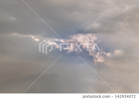 Dramatic Cumulus Clouds Emerging Through Dark Overcast Sky at Golden Hour. Dramatic Cumulus Clouds Emerging Through Dark Overcast Sky at Golden Hour. 142934072