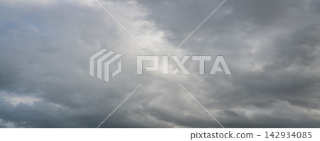 Panoramic view of dramatic gray storm clouds with patches of blue sky Panoramic view of dramatic gray storm clouds with patches of blue sky 142934085