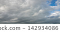 Panoramic view of dramatic gray storm clouds with patches of blue sky 142934086