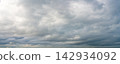 Panoramic view of dramatic gray storm clouds with patches of blue sky 142934092