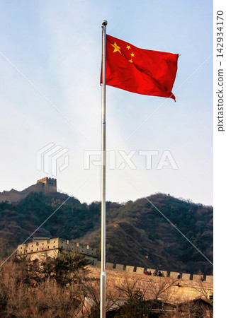 中國國旗和長城在藍天中迎風飄揚。 中國國旗和長城在藍天中迎風飄揚。 142934170