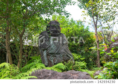 Stone Buddha statue of robed figure at Shiraike Jigoku garden, Beppu Stone Buddha statue of robed figure at Shiraike Jigoku garden, Beppu 142934230
