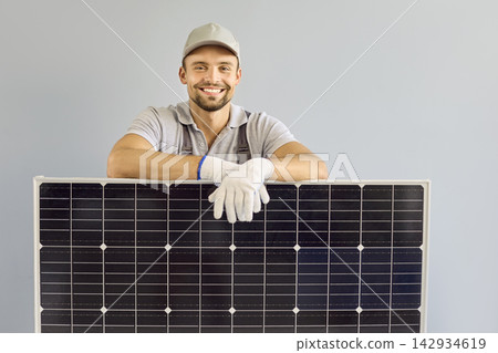 Smiling Solar Panel Installer Holding Photovoltaic Module in Studio Portrait Smiling Solar Panel Installer Holding Photovoltaic Module in Studio Portrait 142934619