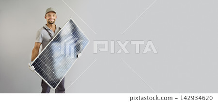 Smiling Solar Technician Holding Photovoltaic Panel Against Gray Background Smiling Solar Technician Holding Photovoltaic Panel Against Gray Background 142934620