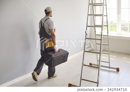 Handyman Carrying Toolbox Beside Ladder During Bright Home Renovation Project 142934710