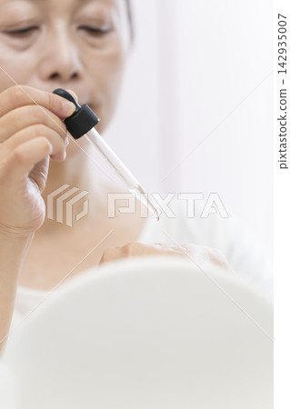 一位老年婦女正在塗抹保養品。 142935007