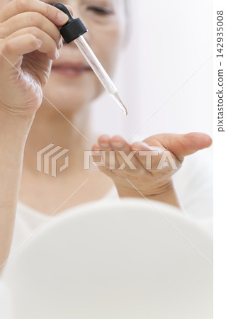 一位老年婦女正在塗抹保養品。 142935008