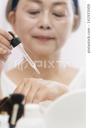 一位老年婦女正在塗抹保養品。 一位老年婦女正在塗抹保養品。 142935009