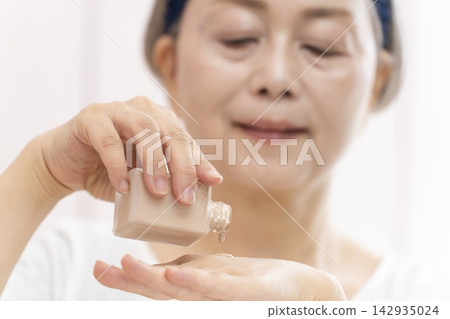The hands of a senior woman applying skincare products. The hands of a senior woman applying skincare products. 142935024