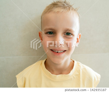 Cheerful boy looking at camera with open smile displaying gap from lost first tooth. Children healthcare, oral hygiene, primary tooth replacement, and joyful lifestyle Cheerful boy looking at camera with open smile displaying gap from lost first tooth. Children healthcare, oral hygiene, primary tooth replacement, and joyful lifestyle 142935187