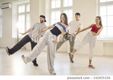 Friends Practicing Coordinated Dance Moves in Sunlit Modern Studio Together 142935330