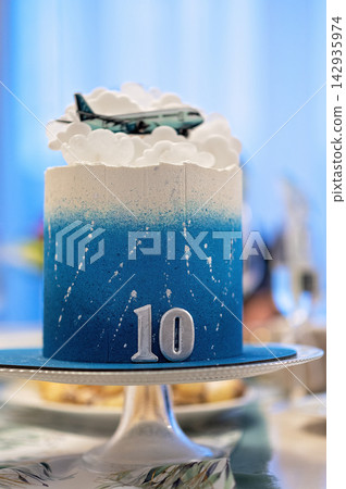 Blue ombre birthday cake with airplane decoration and number ten on silver cake stand Blue ombre birthday cake with airplane decoration and number ten on silver cake stand 142935974