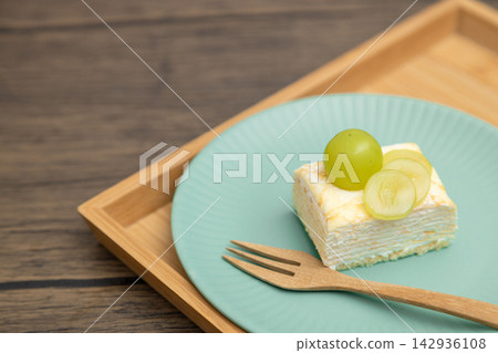 A cross-section of a mille-crêpe cake, topped with Shine Muscat grapes. A cross-section of a mille-crêpe cake, topped with Shine Muscat grapes. 142936108