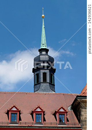 Elegant slate spire tower with golden ball on red tile roof Elegant slate spire tower with golden ball on red tile roof 142936621