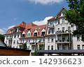 Large residential apartment complex with white walls and red tiled roofs 142936623