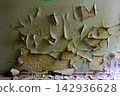 Texture of heavily peeling and curling old paint on a weathered concrete wall 142936628