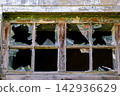 Broken glass windows in old wooden frame of an abandoned building close up 142936629
