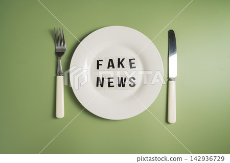 Fake news served words on plate with cutlery on green background, misinformation and media manipulation concept Fake news served words on plate with cutlery on green background, misinformation and media manipulation concept 142936729