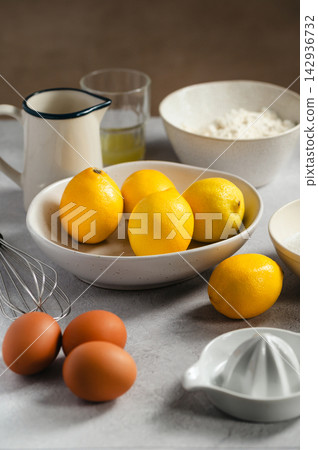 Lemon cake ingredients prepared for baking, closeup bowl with fresh lemons Lemon cake ingredients prepared for baking, closeup bowl with fresh lemons 142936732