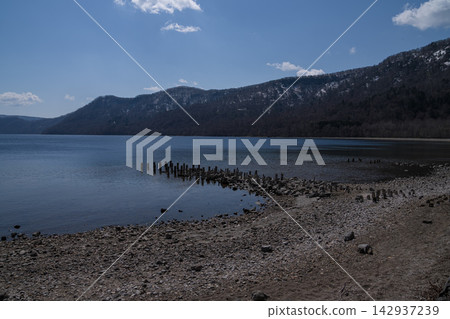 Old stakes remaining on the shore of Lake Shikotsu and the lake surface in spring. Old stakes remaining on the shore of Lake Shikotsu and the lake surface in spring. 142937239