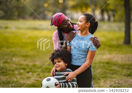 Loving African American mother embracing children in park Loving African American mother embracing children in park 142938252