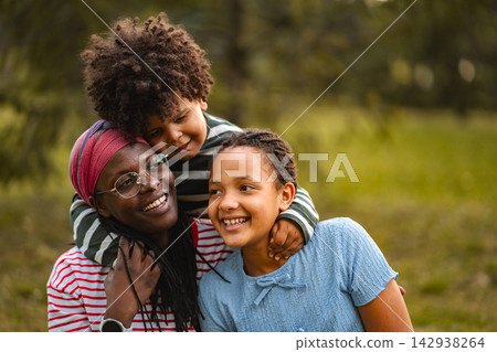 African American mother embracing children in park African American mother embracing children in park 142938264