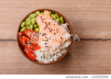 An Asian style bowl with shrimp, edamame, tomatoes, and wakame. A shrimp and vegetable bowl 142938309