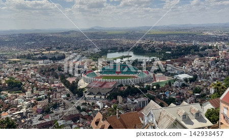 A panoramic view of the city under a clear sky from a hilltop. 142938457